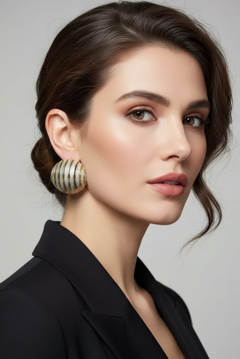 Side view of a woman featuring chunky ribbed dôme statement earrings, highlighting the unique striped two-tone texture and bold sculptural jewelry design.