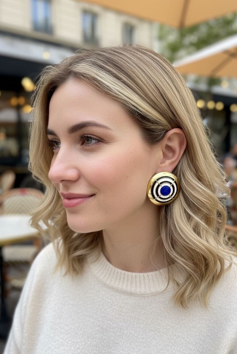 Model wearing All-Glows Grand Muse cobalt blue enamel dome studs with a cream knit sweater. These bold architectural earrings add a touch of casual luxury to everyday autumn and winter outfits.