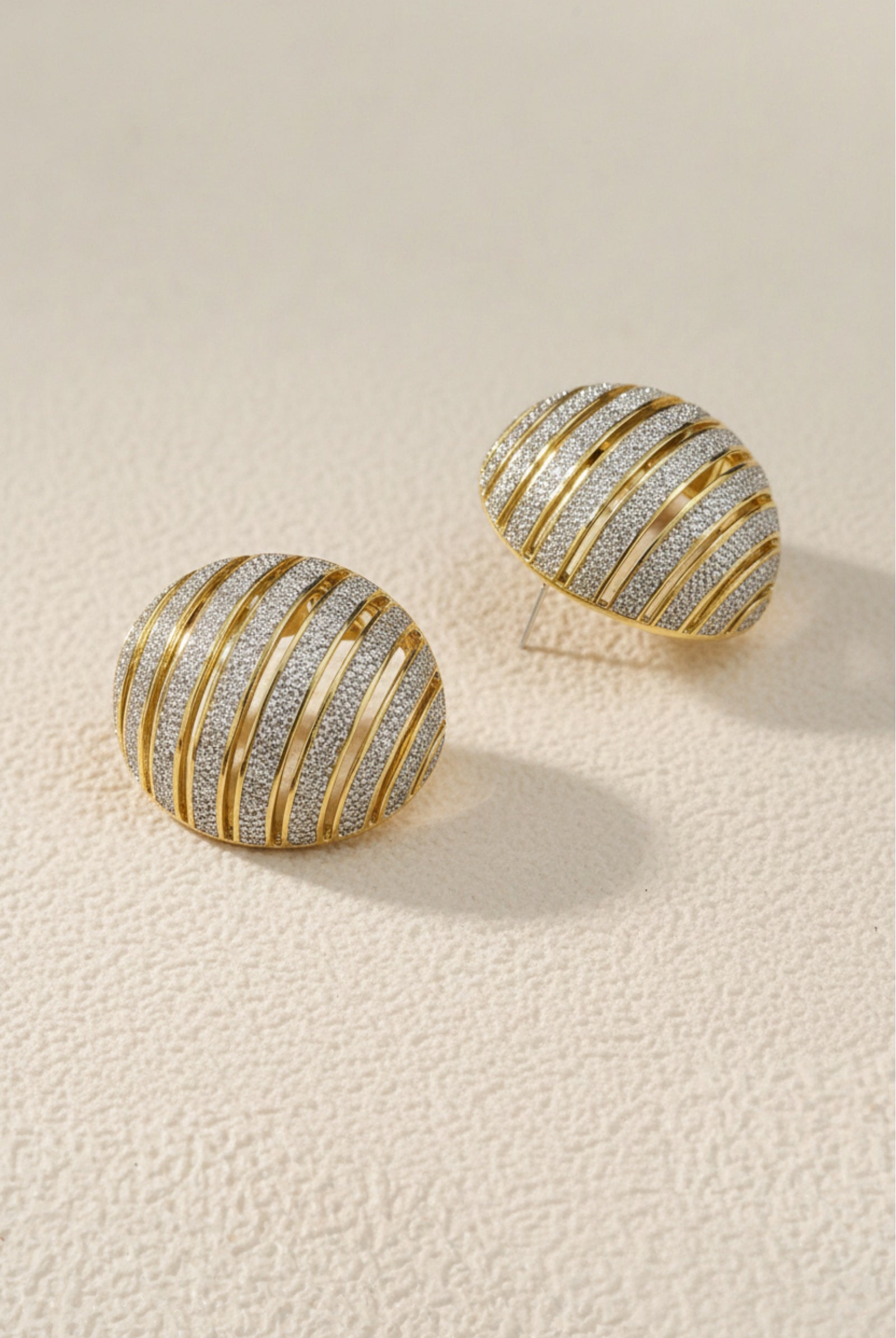 Chunky ribbed two-tone gold and silver dome earrings, mixed metal jewelry trend 2026.
