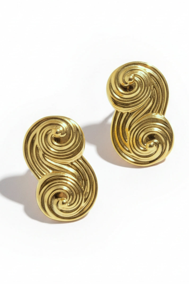 Close-up product shot of Seraphina Sculptural Swirl Earrings, textured gold ribbon design, high-quality infinity studs.