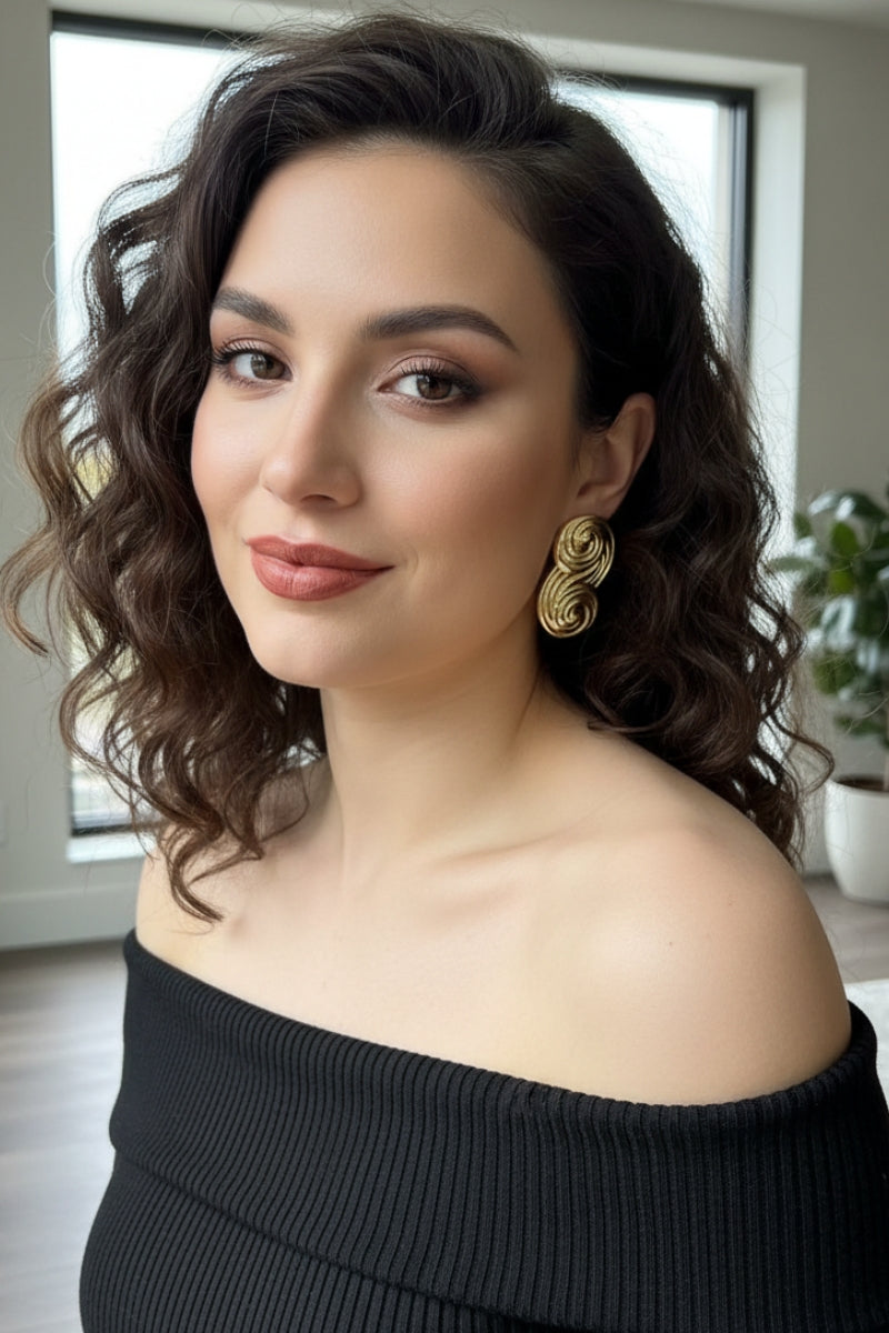 Seraphina sculptural swirl gold earrings featuring an architectural infinity loop design for minimalist luxury.