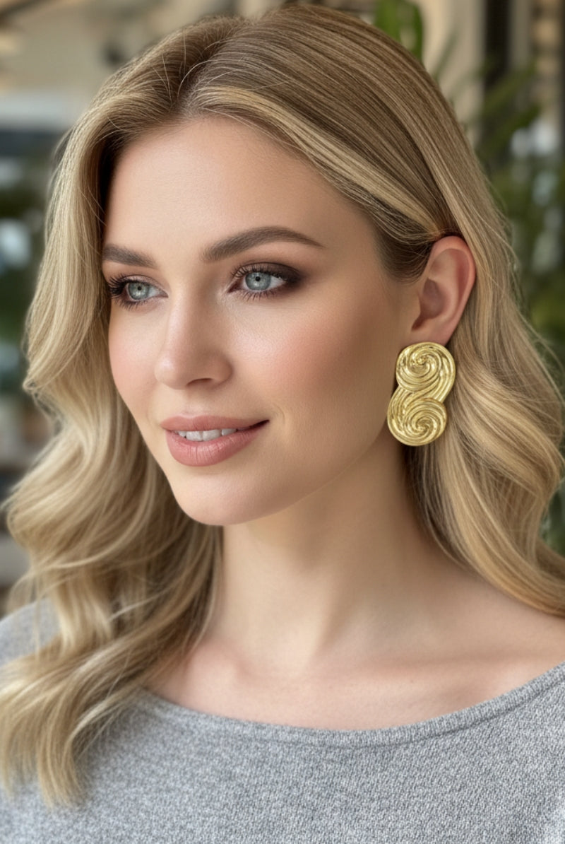 Seraphina gold statement earrings worn with casual grey knitwear, versatile everyday luxury jewelry for New York boutiques.