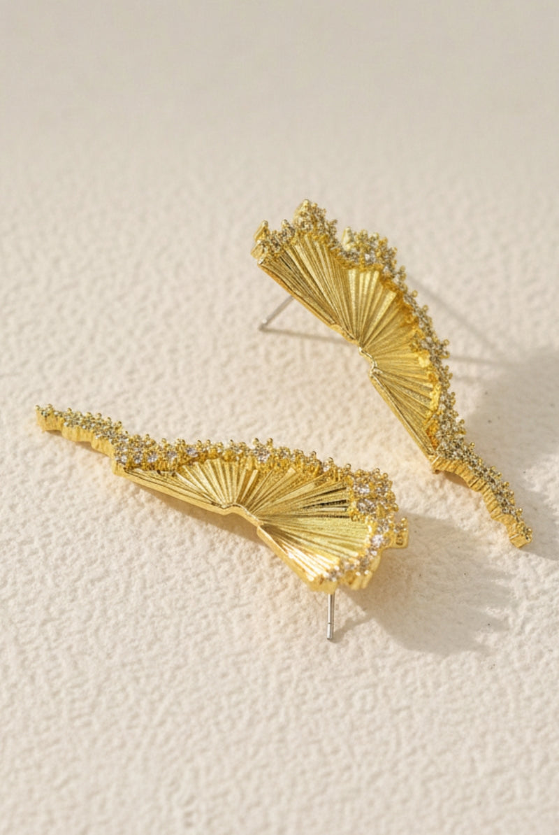 A high-angle product photograph of Aurelia fan-shaped gold earrings with irregular pavé cubic zirconia edge with S925 silver posts. These sculptural nature-inspired earrings are adorned with shimmering Swarovski crystals. Perfect hypoallergenic everyday luxury under $50.