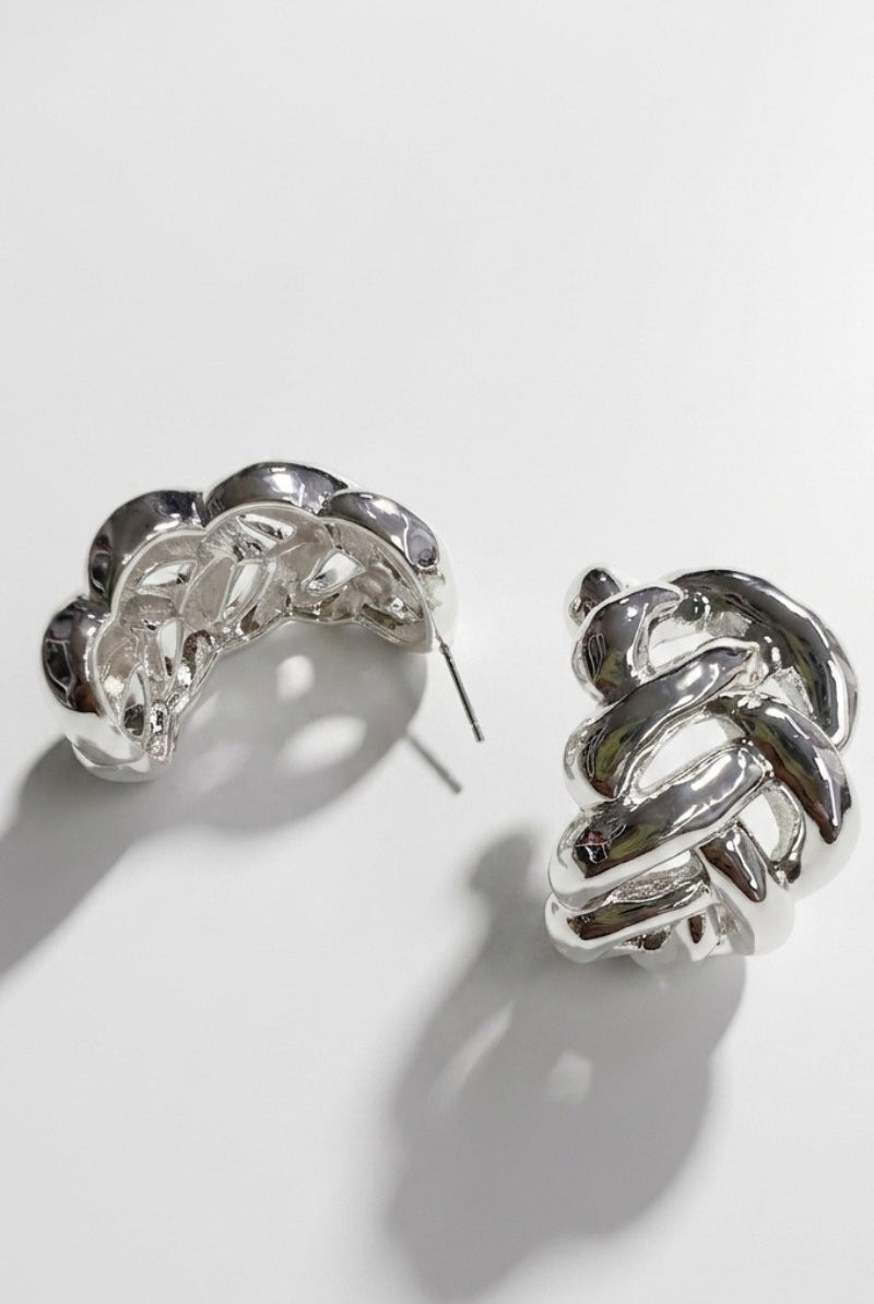 Pair of braided liquid silver half-hoop earrings on a white background