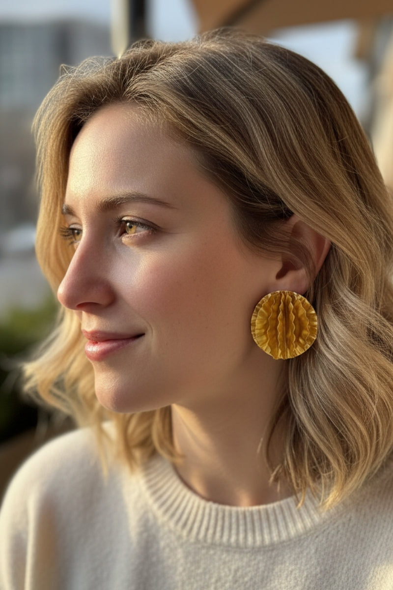 Model wearing oversized gold textured disc earrings, showcasing a bold elegance aesthetic perfect for London streetwear.