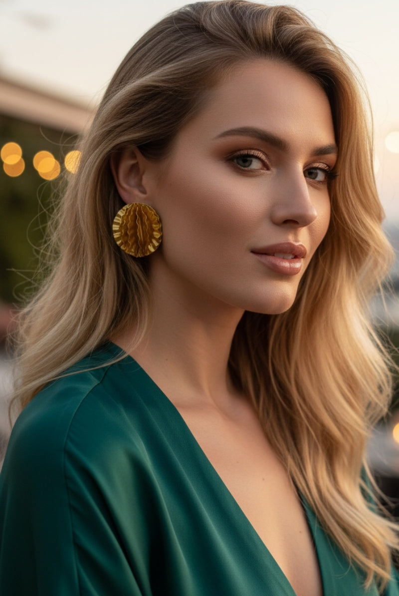 Model wearing Aurelia large gold disc statement earrings with emerald green silk dress, elegant evening gala jewelry for women in New York and London.