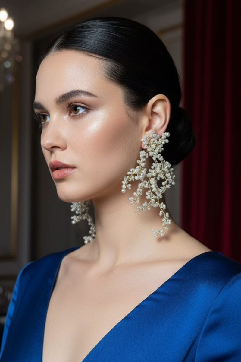 A model showcasing All Glows organic fluid pearl dangles, perfect for an upscale Hamptons garden party or summer social event.