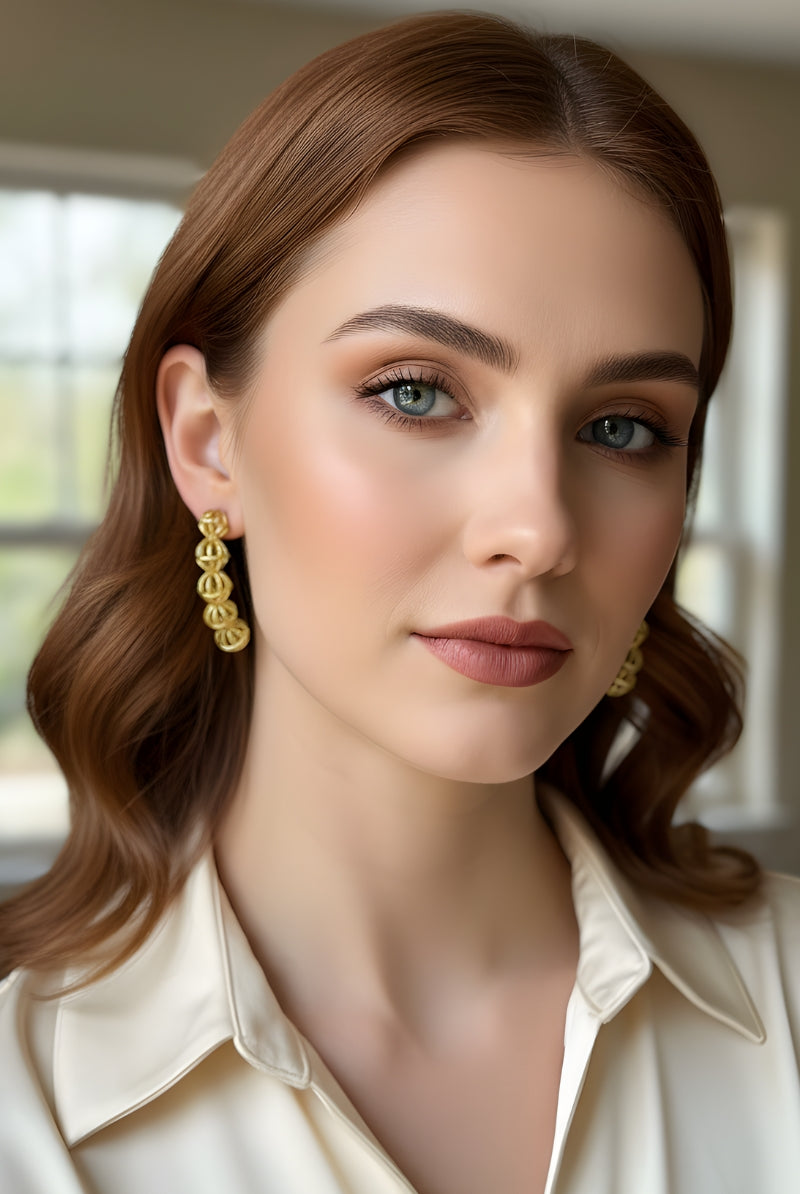 Close-up portrait of a brunette woman wearing a cream collar shirt and 5-sphere bold statement earrings, illustrating a comfortable, hypoallergenic nickel-free jewelry choice for daily sophisticated wardrobe wear.