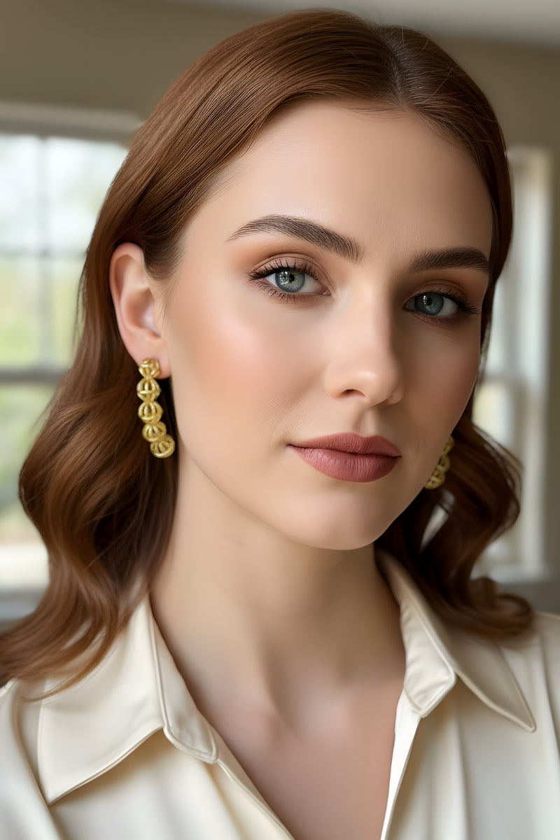 Close-up portrait of a brunette woman wearing a cream collar shirt and 5-sphere bold statement earrings, illustrating a comfortable, hypoallergenic nickel-free jewelry choice for daily sophisticated wardrobe wear.