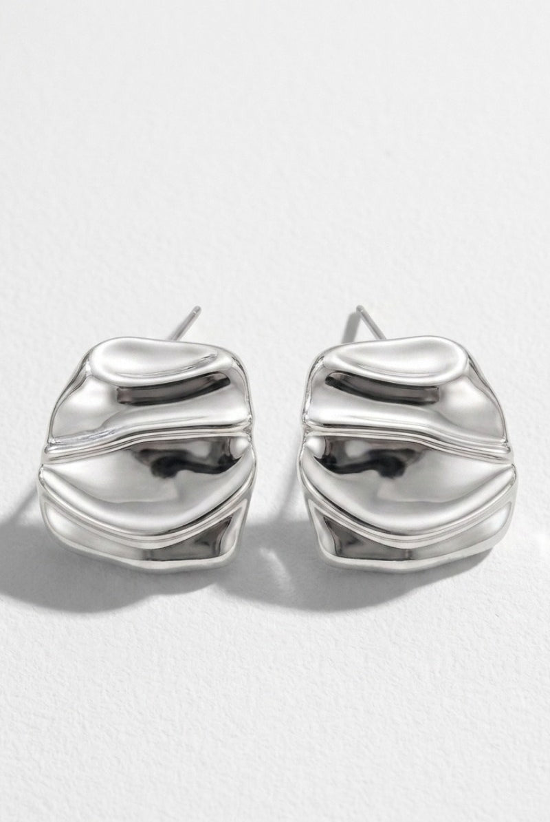 Pair of liquid silver square statement stud earrings on a white background
