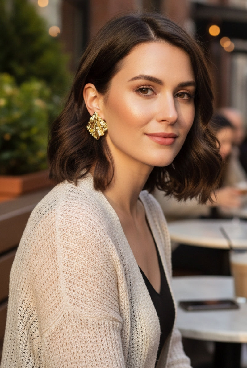 A portrait of a woman wearing gold Mirage Earrings with a textured sculptural design, perfect for elegant everyday luxury.