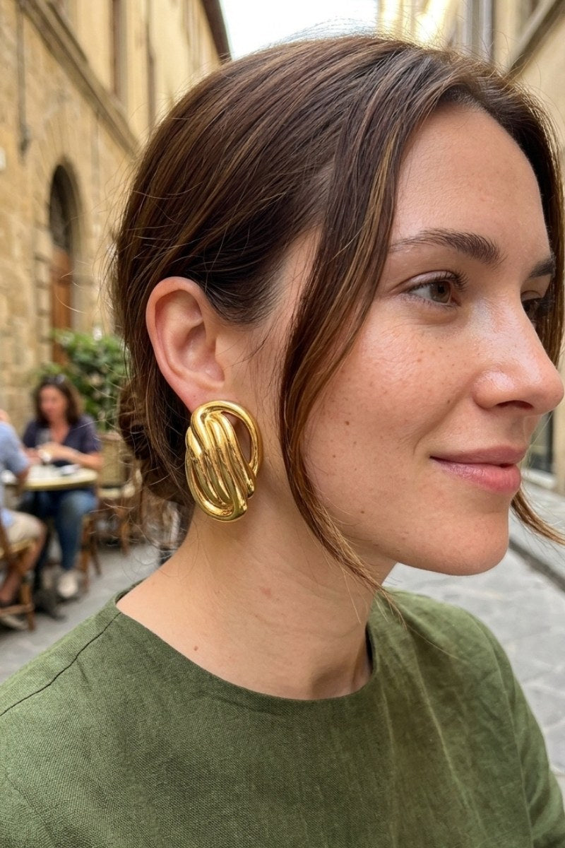 Model wearing sculptural oval knot statement stud earrings, view 4