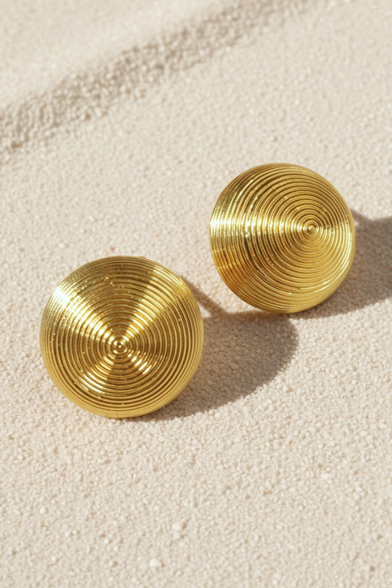 Close-up of gold-plated honeycomb earrings showing the intricate pleated texture and high-shine metallic finish.