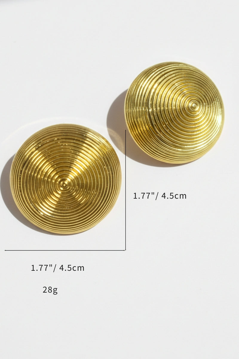 Macro shot of the Juno gold concentric 1.77", 28g circle earrings, displaying the 3D ribbed texture and substantial dome shape.