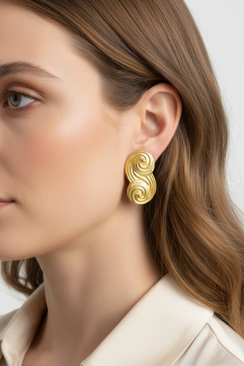 Side profile view of Seraphina small sculptural gold earrings, showcasing the unique swirl design and premium 18K gold plating.