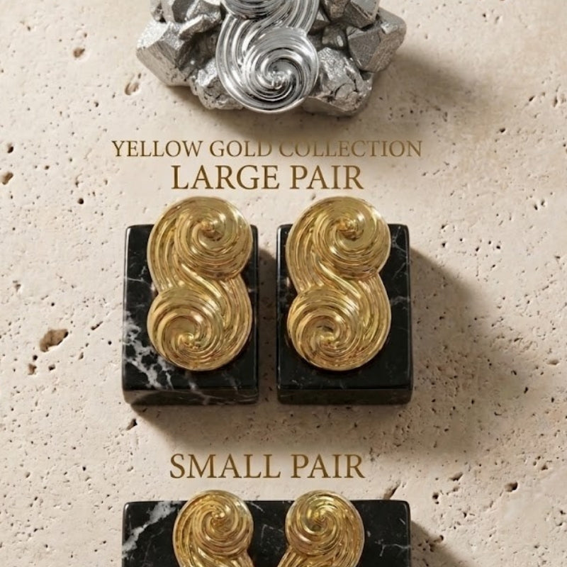 An elegant display of the Seraphina collection, featuring small and large pairs in both yellow gold and white gold on marble bases.