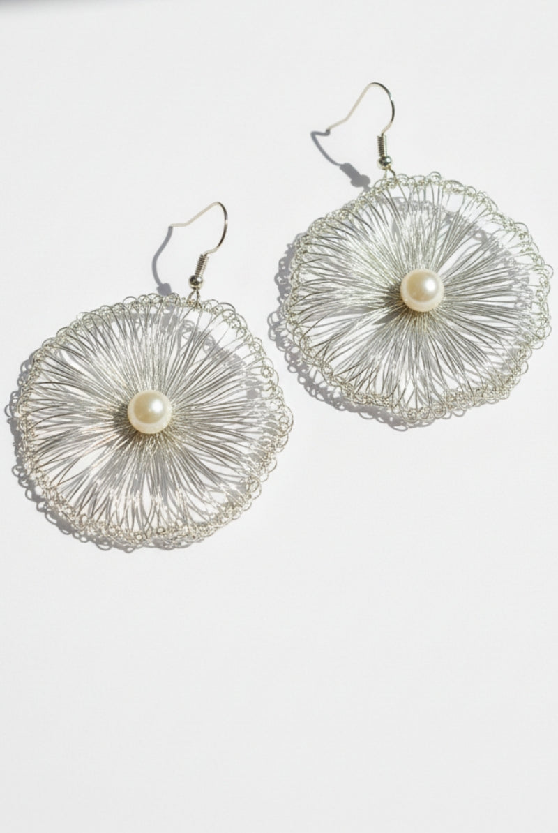 Side view of All Glows Lyra hand-crocheted earrings in tarnish-resistant gold wire, featuring an intricate round filigree lace pattern and high-luster shell pearl.