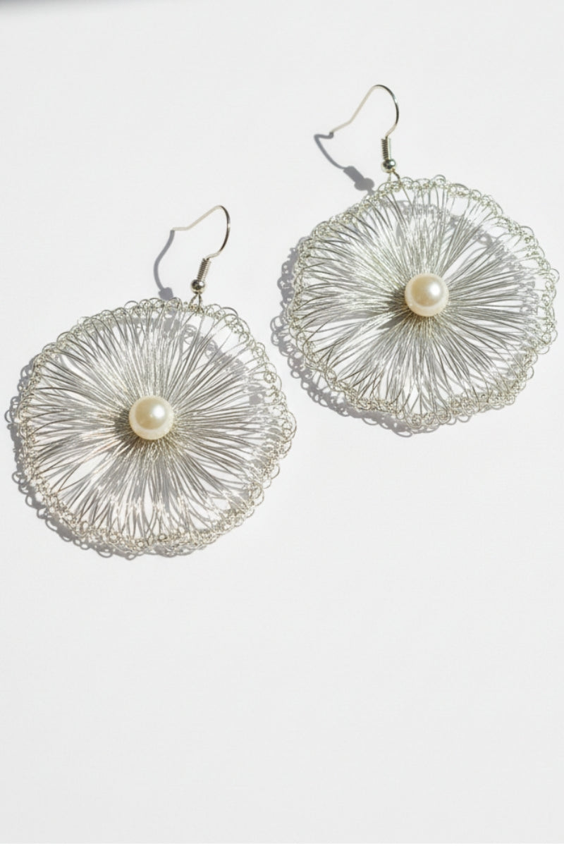 Side view of All Glows Lyra hand-crocheted earrings in tarnish-resistant gold wire, featuring an intricate round filigree lace pattern and high-luster shell pearl.