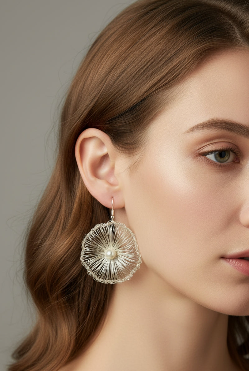 A detailed close-up portrait of a model showcasing the shimmering, hand-woven texture of All Glows Lyra gold wire crocheted dangles for an elegant look.
