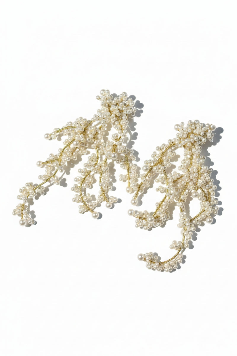 Detailed product view of All Glows 18K gold plated brass fluid pearl earrings, showing the high-grade shell pearl and irregular metal texture.