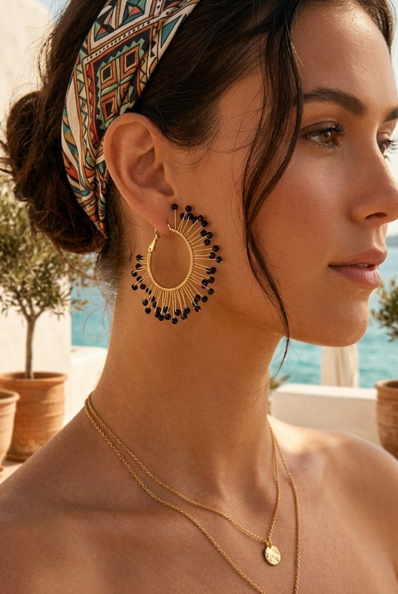 Model wearing solburst wire-wrapped beaded sunburst hoop earrings in the Noir variant, view 3
