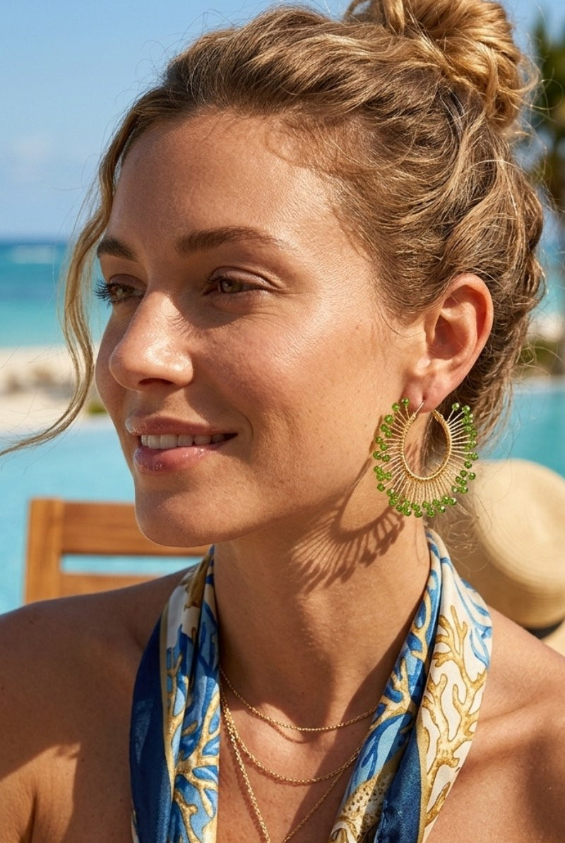 Model wearing solburst wire-wrapped beaded sunburst hoop earrings in the Olive variant, view 1