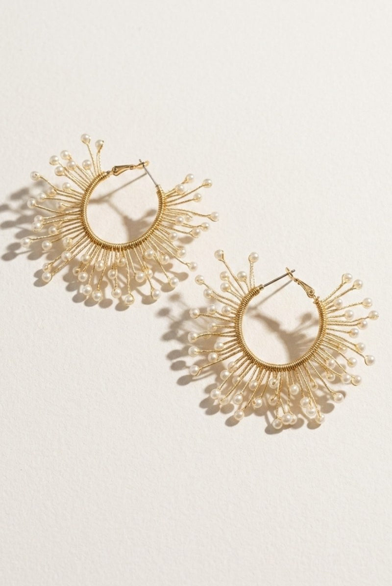 Solburst wire-wrapped beaded sunburst hoop earrings in the Pearl variant on a warm beige background