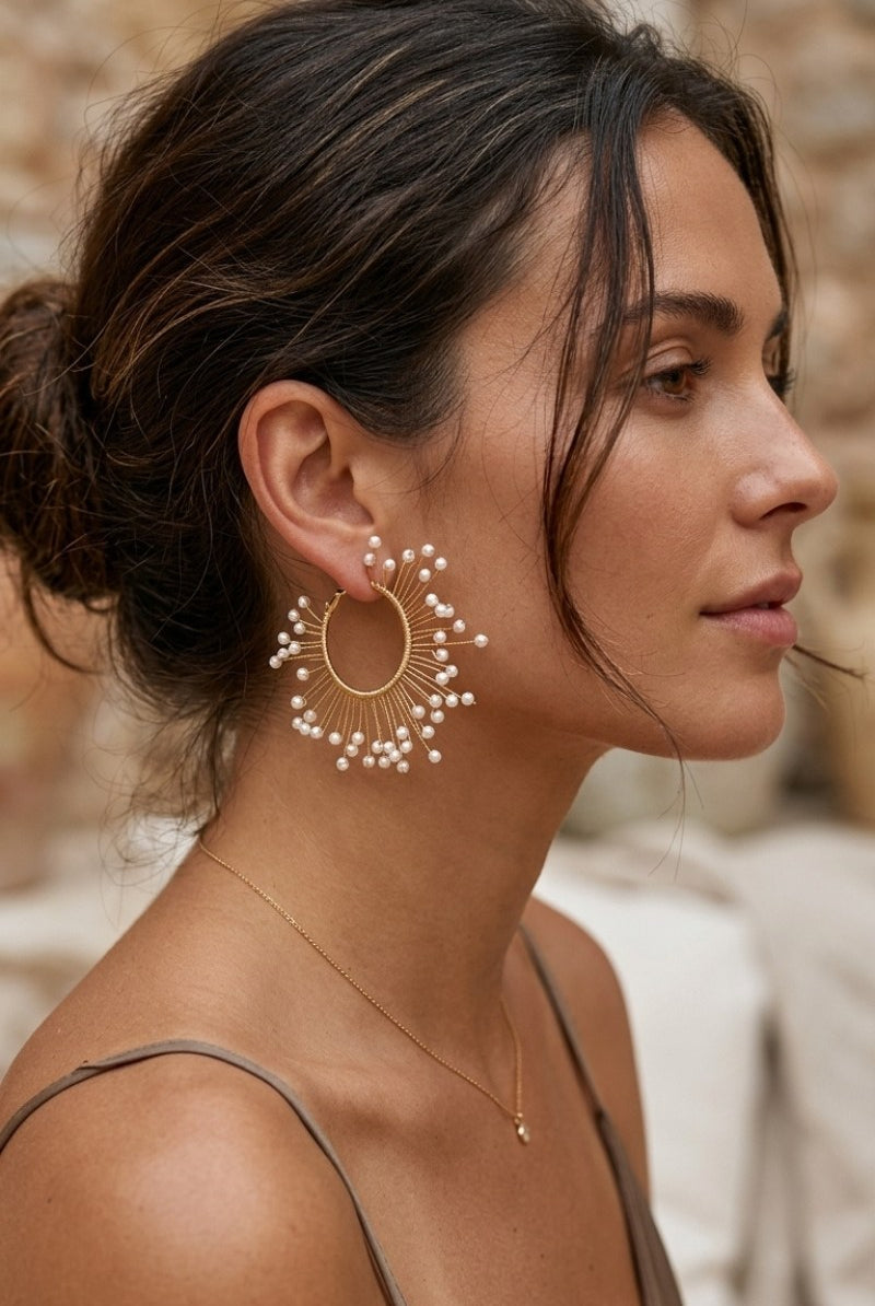 Model wearing solburst wire-wrapped beaded sunburst hoop earrings in the Pearl variant, view 3