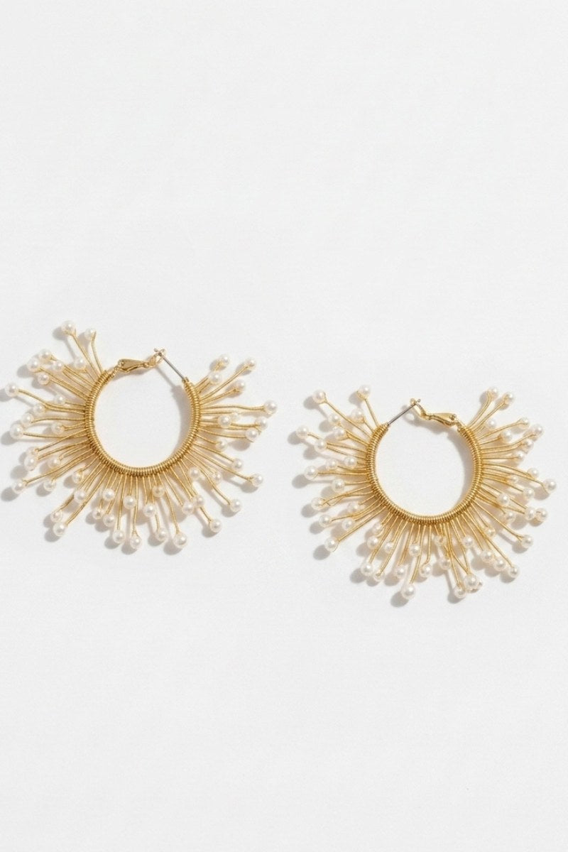 Pair of solburst wire-wrapped beaded sunburst hoop earrings in the Pearl variant on a white background