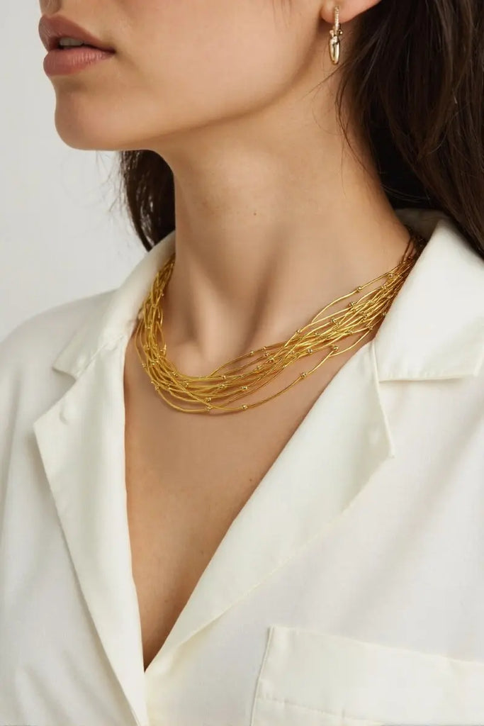Model wearing handmade gold-plated necklace with layered design