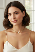 model wearing a 18K plated cubic bead with central pearl necklace.