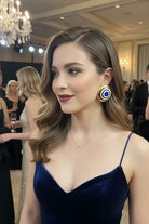 Elegant model in a navy blue velvet gown wearing Grand Muse architectural enamel earrings. These luxury statement studs are designed to complement formal evening wear at gala dinners.