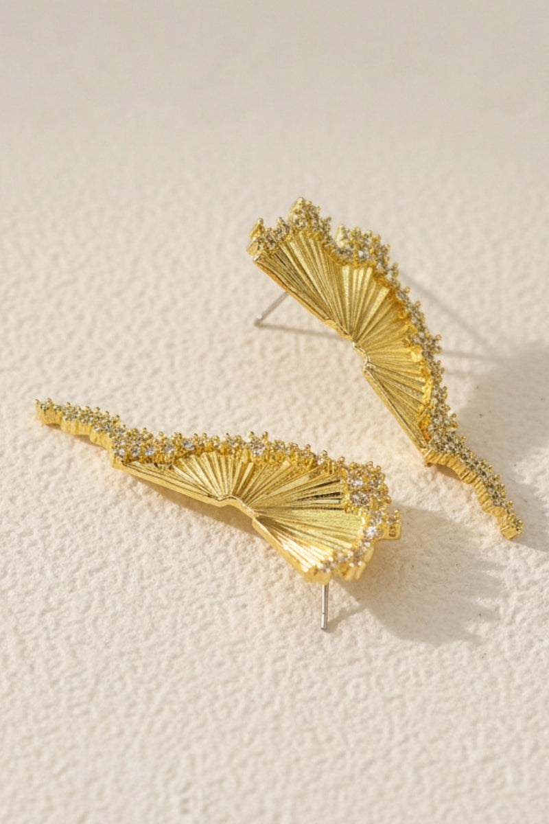 A high-angle product photograph of Aurelia fan-shaped gold earrings with irregular pavé cubic zirconia edge with S925 silver posts. These sculptural nature-inspired earrings are adorned with shimmering Swarovski crystals. Perfect hypoallergenic everyday luxury under $50.