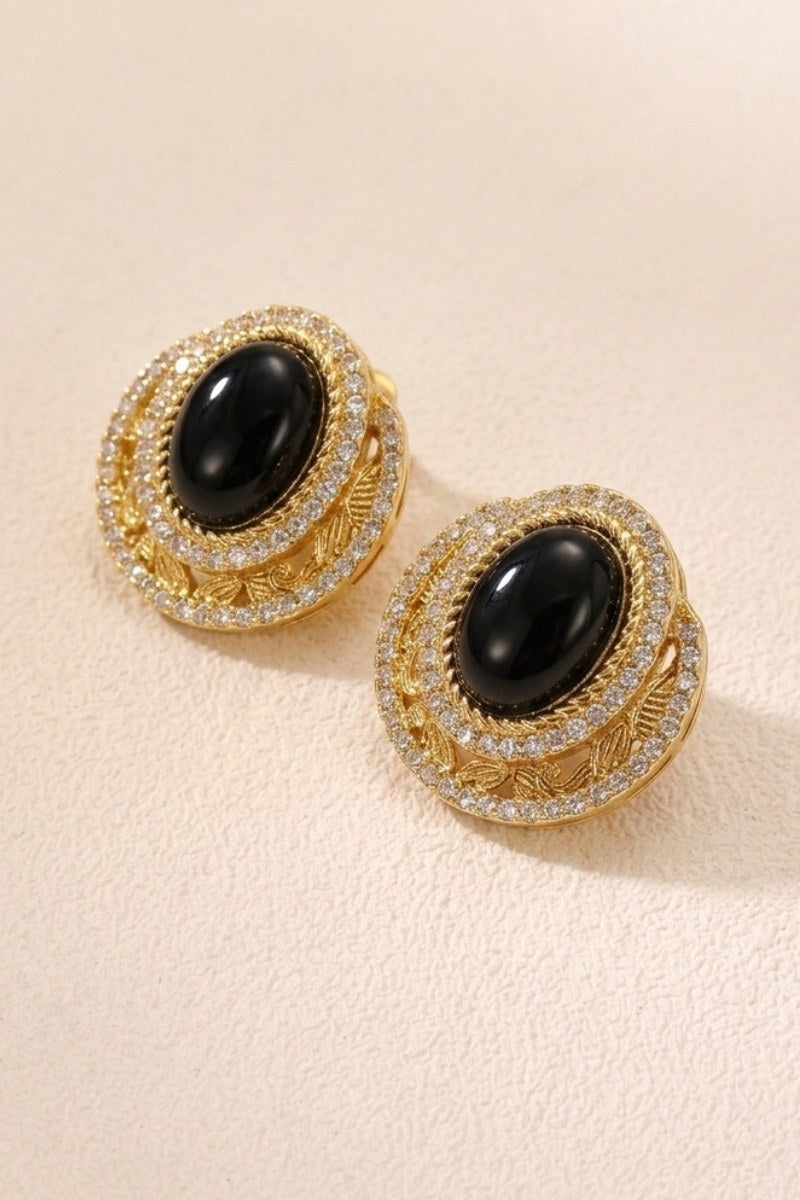 Black Czech crystal halo stud earrings on a warm beige background