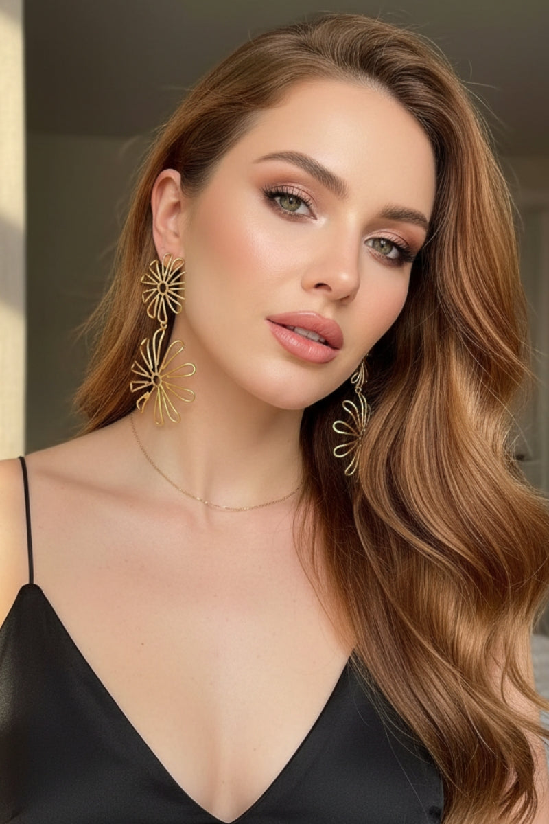 Oversized gold floral statement earrings paired with a black cocktail dress, elegant evening jewelry for London gala events.