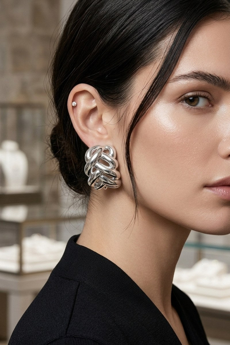Model wearing braided liquid silver half-hoop earrings, view 3