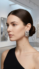 Model wearing braided liquid silver half-hoop earrings, view 6