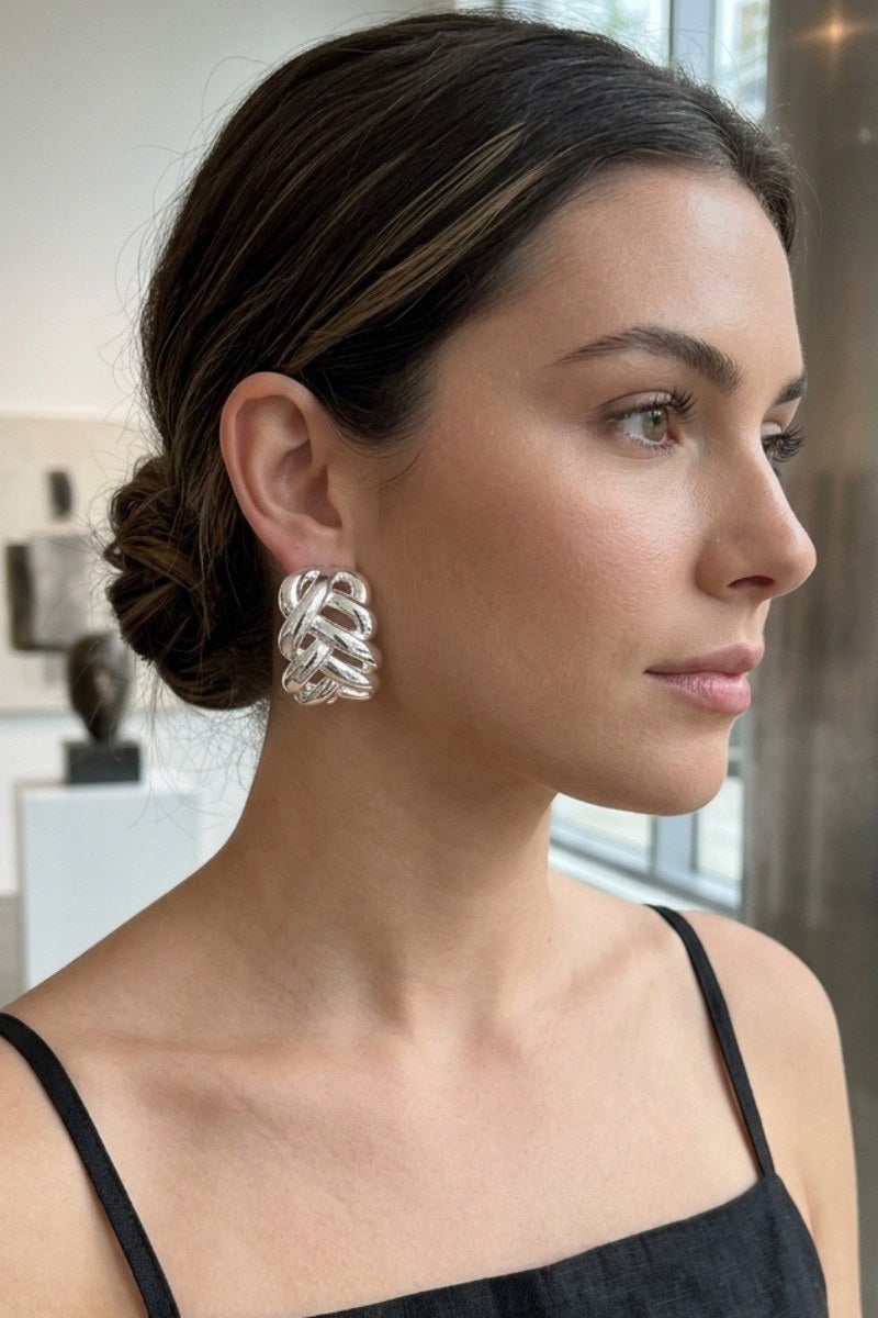 Model wearing braided liquid silver half-hoop earrings, view 1
