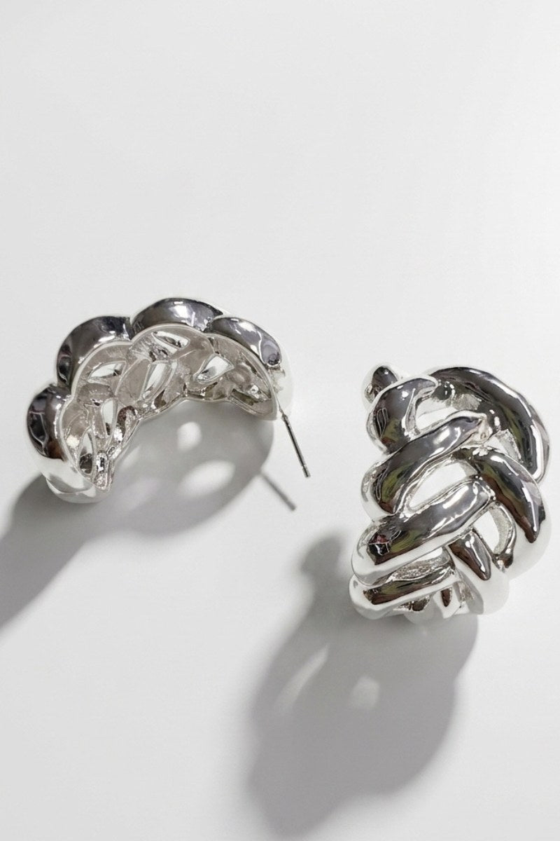 Pair of braided liquid silver half-hoop earrings on a white background