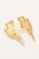 Studio flatlay of the Chrysalis 18K gold plated wing earrings showcasing the detailed ribbed texture and the back stud and clip-on mechanisms.