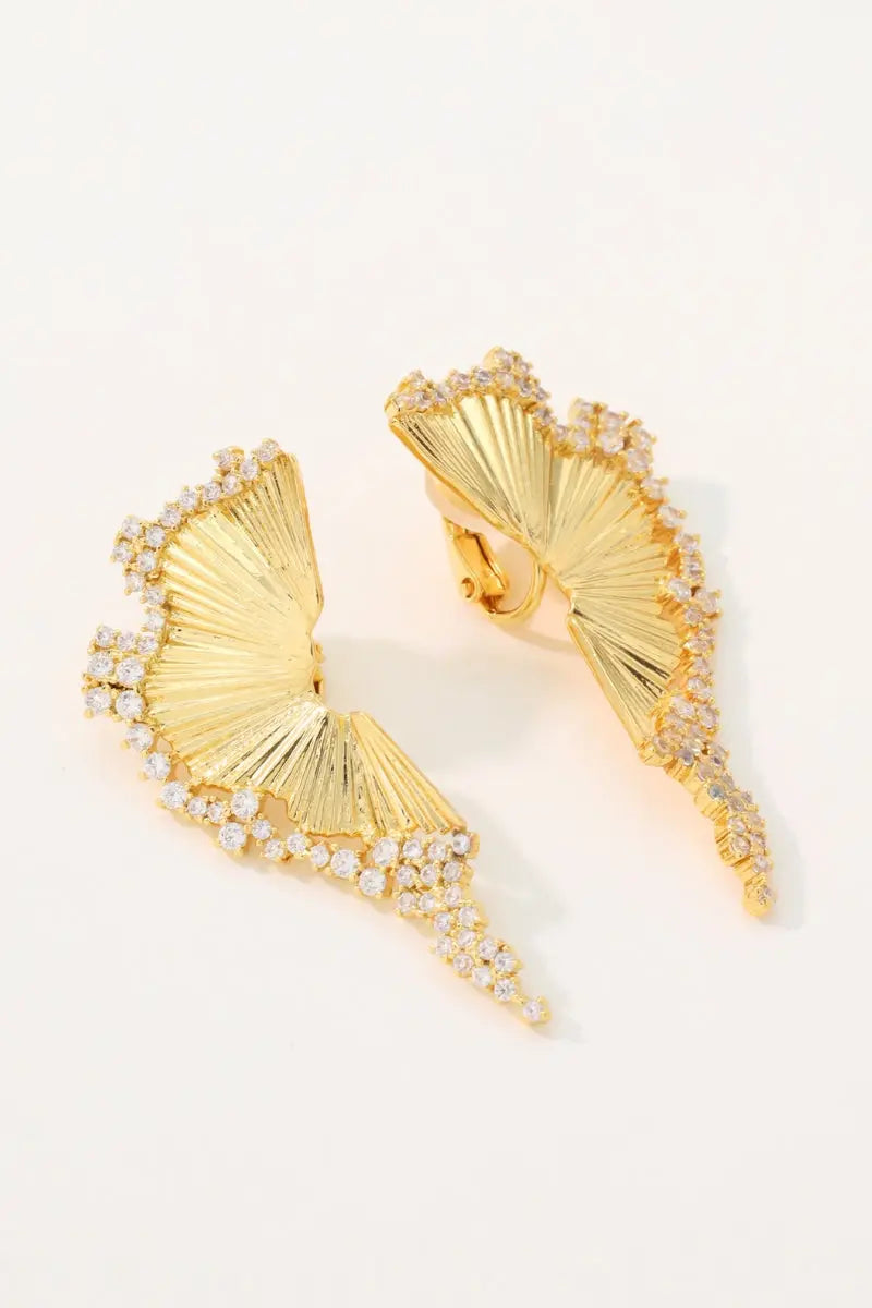 Studio flatlay of the Chrysalis 18K gold plated wing earrings showcasing the detailed ribbed texture and the back stud and clip-on mechanisms.