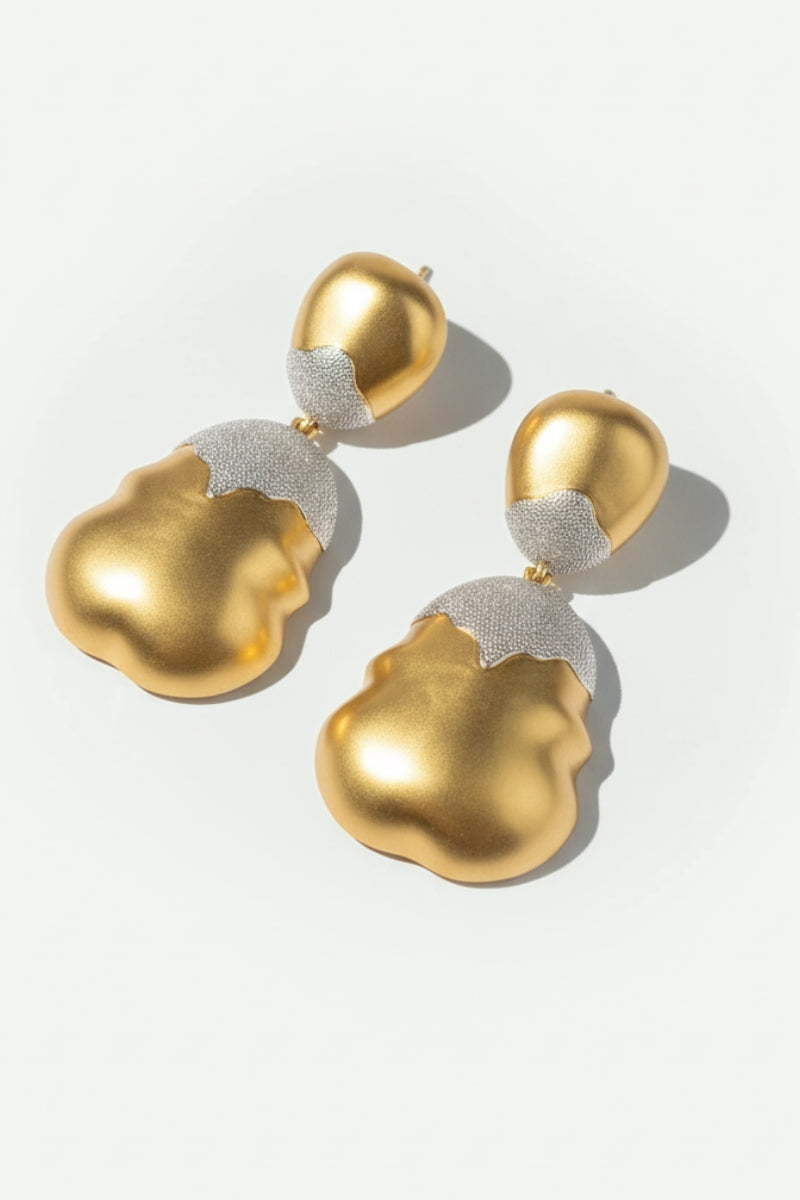 High-detail view of Luna mixed metal earrings with a shimmering frosted silver top and wavy molten gold bottom.