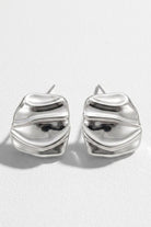 Pair of liquid silver square statement stud earrings on a white background