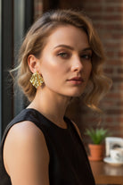 Close-up side profile of a model showcasing the unique textured finish of the gold Mirage Earrings for a modern look.