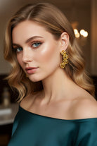 A close-up portrait of a blonde woman in an off-the-shoulder emerald satin gown. She wears the dramatic 5-sphere curved drop earrings, capturing a classic old-money aesthetic perfect for gala dinners or formal guest styling.