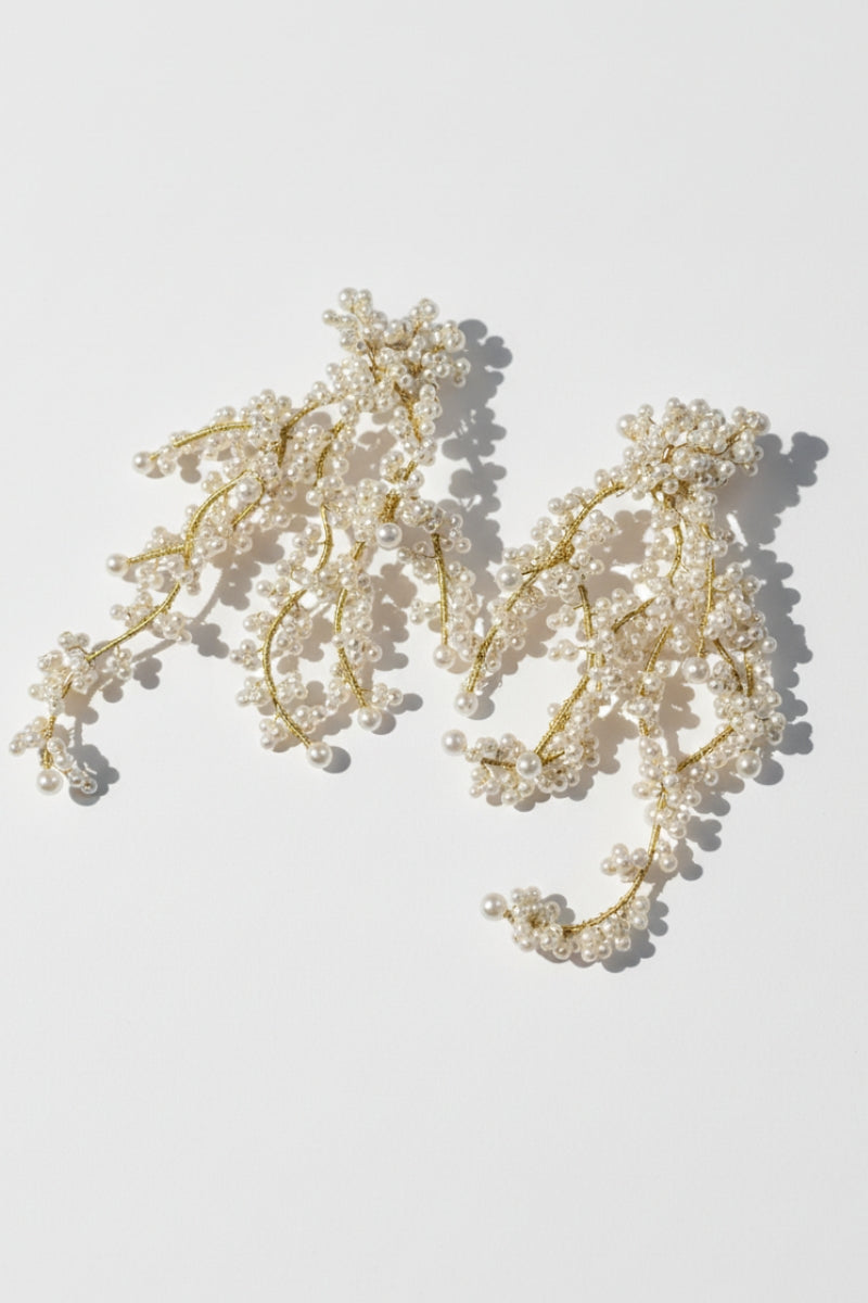 Close-up profile of a model wearing molten gold shell pearl earrings, capturing a refined Malibu sunset dinner aesthetic.