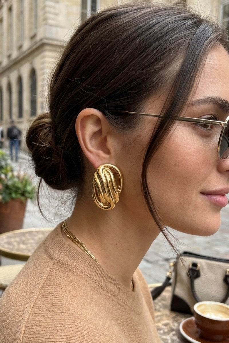 Model wearing sculptural oval knot statement stud earrings, view 3