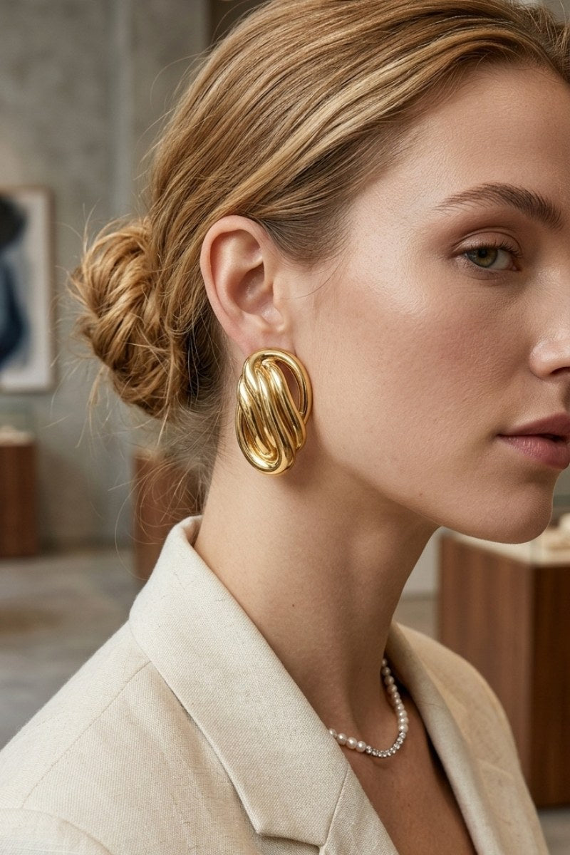 Model wearing sculptural oval knot statement stud earrings, view 5