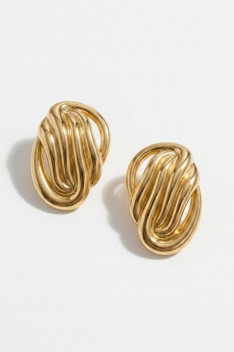 Pair of sculptural oval knot statement stud earrings on a white background, view 2