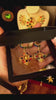 A vibrant close-up video showcase of tarnish-resistant gold dangles, featuring a bold, openwork cross-shaped setting filled with round multi-color gemstones, including red, green, blue, yellow, and pastel tones. A hand holds and rotates the earrings, suitable for a sophisticated evening party look.